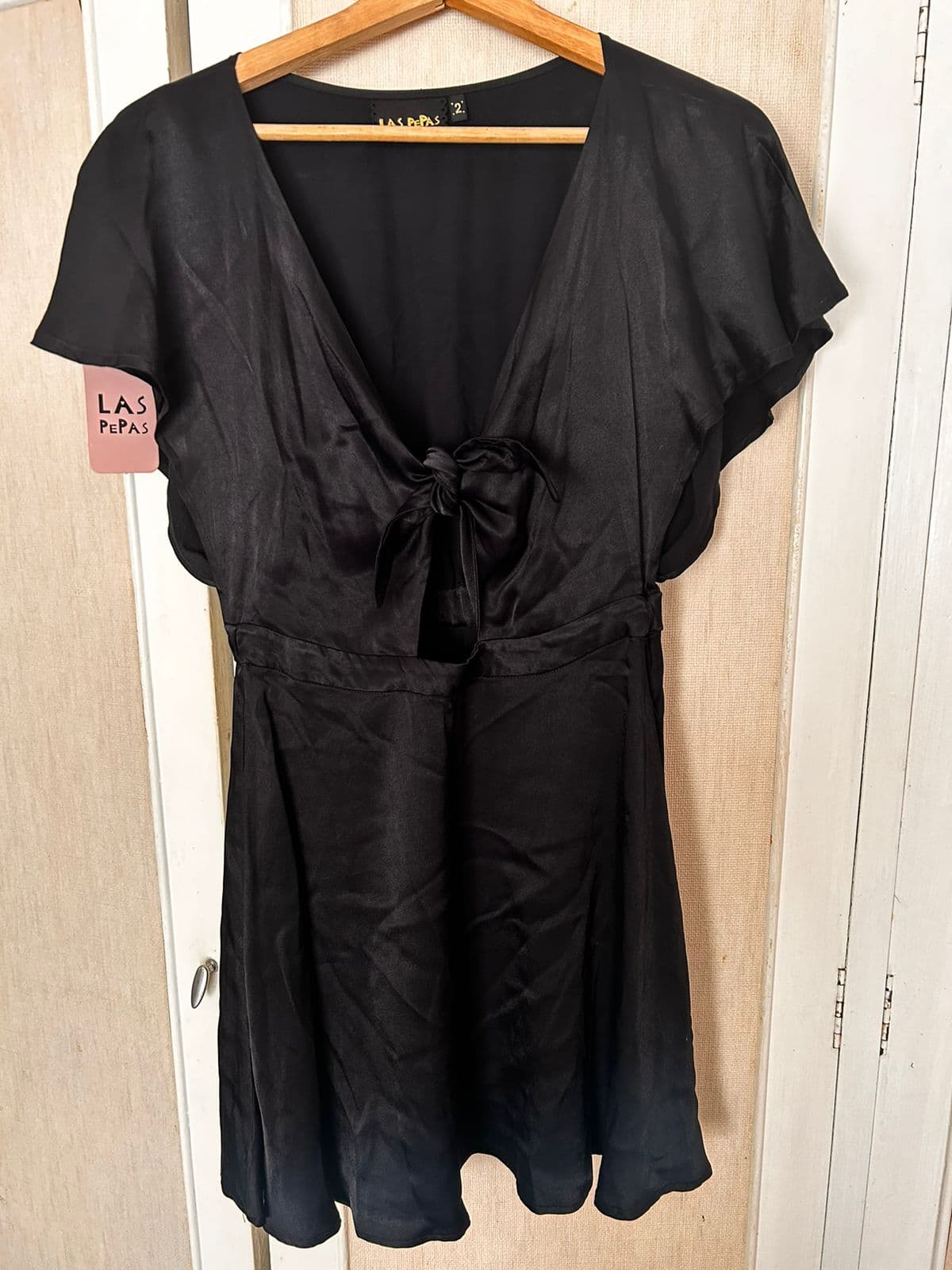 Vestido corto negro con lazo frontal. Es todo nuevo con etiqueta marca LAS PEPAS